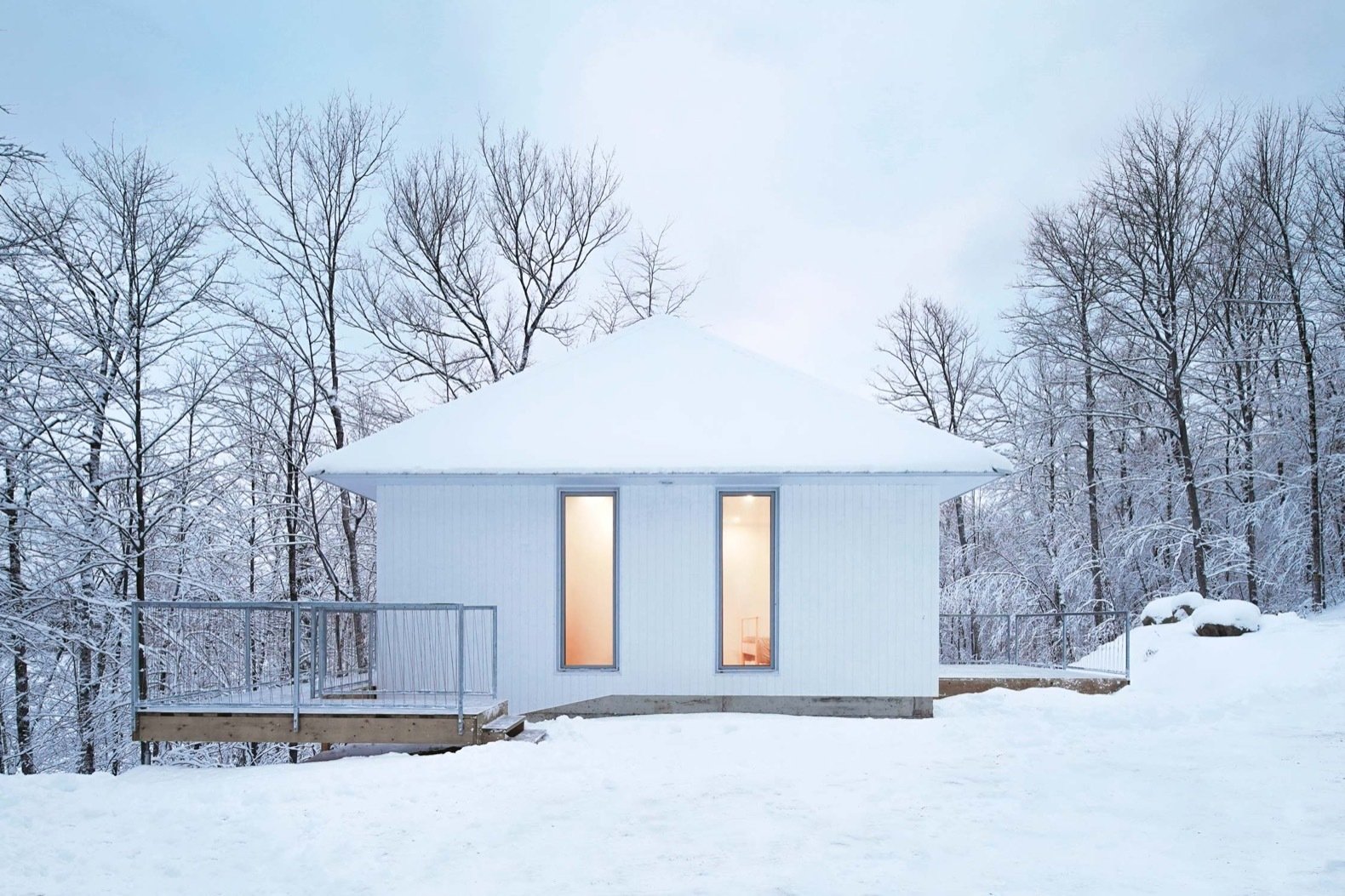 This Snow-White Cabin Disappears Into a Wintry Lakeside